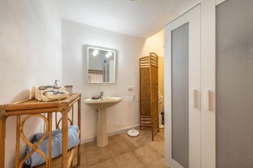 a bathroom with a sink and a toilet and a mirror at Casa Buenavista Villasimius in Villasimius