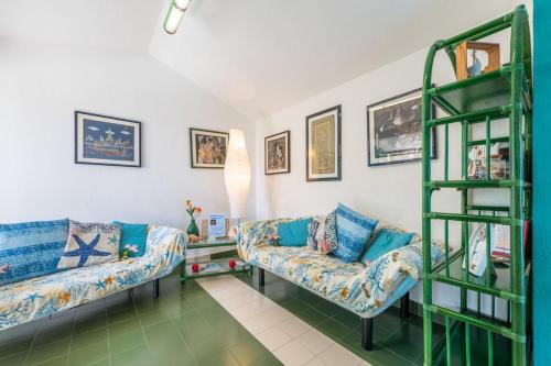una sala de estar con 2 sofás y un estante en Casa Buenavista Villasimius, en Villasimius