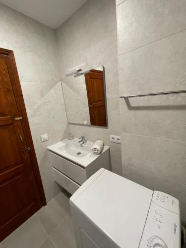 a bathroom with a sink and a toilet and a mirror at Apartamento Siesta Mar 1 Apartamento 26 Cala en Porter in Cala'n Porter