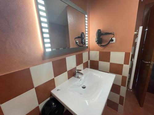 a bathroom with a sink and a mirror at APARTAMENTOS RioMonte 5 - DeLuxe con Jacuzzi in Boltaña