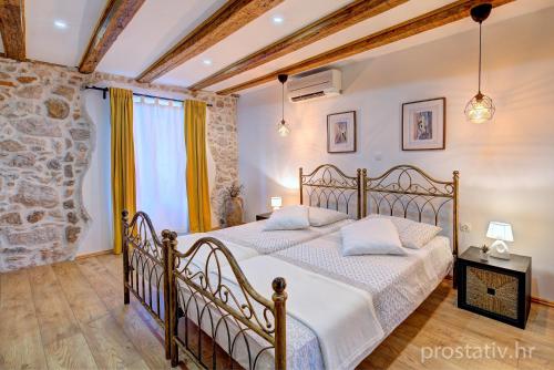 a bedroom with a bed and a stone wall at Apartment Seka Oldtown in Senj