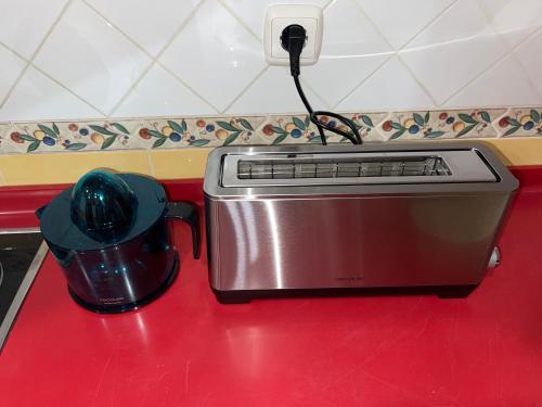 a toaster sitting on a red counter next to a pot at APARTAMENTOS RioMonte 5 - DeLuxe con Jacuzzi in Boltaña