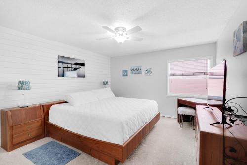a bedroom with a bed and a desk and a window at Villas on the Gulf unit C5 in Pensacola Beach