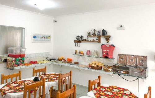 a kitchen with two tables and chairs in a room at Pousada d'Ibiza in Itanhaém