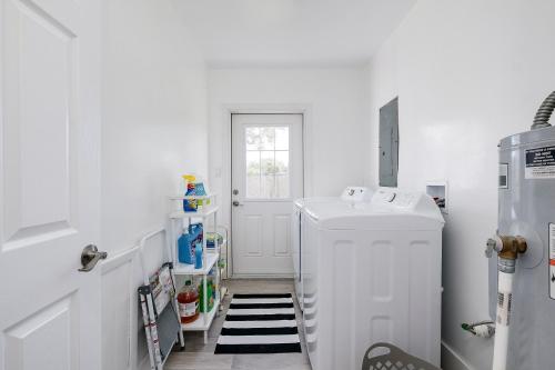 a white laundry room with a washer and dryer at Coastal Cove Chateau in Venice