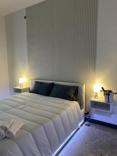 1 dormitorio con 1 cama blanca grande y 2 lámparas en Labanca’s Home en Matera