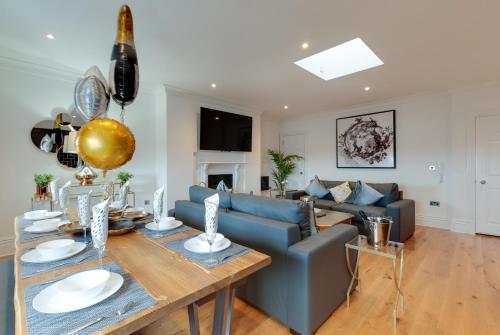 ein Wohnzimmer mit einem blauen Sofa und einem Tisch in der Unterkunft 80 by Elite in Liverpool