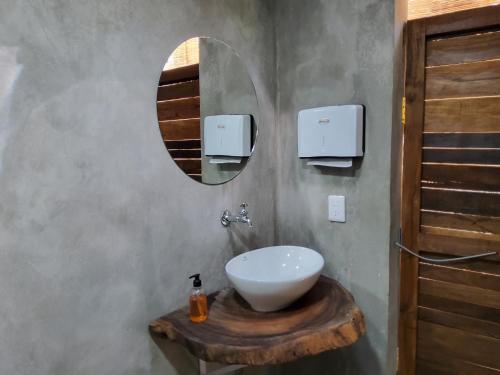 a bathroom with a white sink and a mirror at Hakuna Matata Glamping in Bacalar