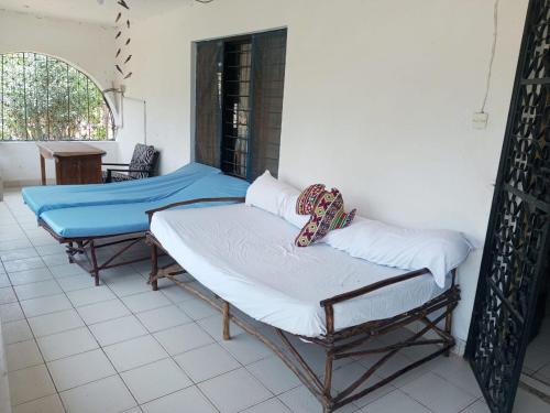 a room with two beds and a table at Fred Hunter Villa in Tiwi