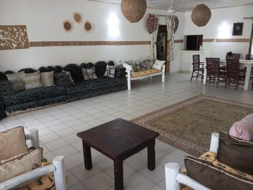 a living room with couches and a table in a room at Fred Hunter Villa in Tiwi