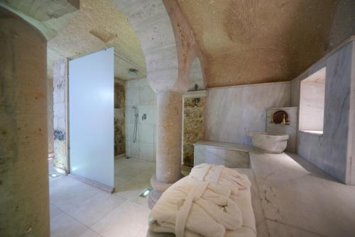 a large bathroom with a tub and a toilet at Shoestring Cave House in Goreme