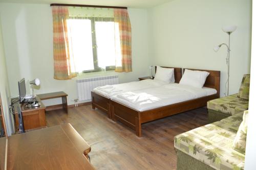 a bedroom with a bed and a table and a window at DE-YAN Guest House in Oreshak