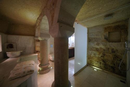 a bathroom with a pillar and a shower in a room at Shoestring Cave House in Goreme