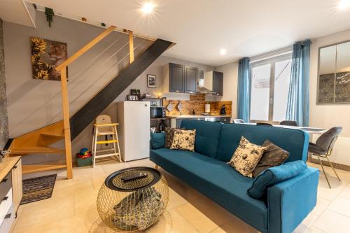 un salon avec un canapé bleu et une cuisine dans l'établissement Le P'titVaillant - Maison, à Romorantin-Lanthenay