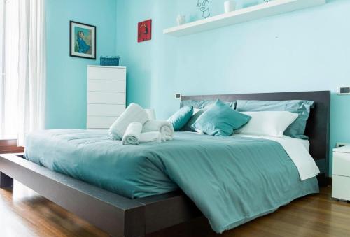 a blue bedroom with a large bed with blue walls at Light Blue House in Montesilvano