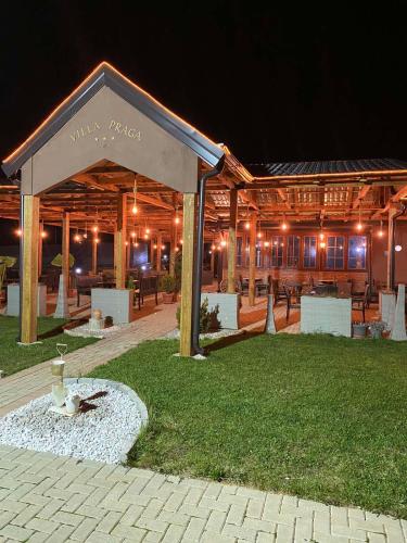 a wooden building with a pavilion at night at Complex Praga in Gorno Lakočerej