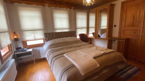 1 dormitorio con 1 cama grande en una habitación con ventanas en Utku Konağı, en Bartın