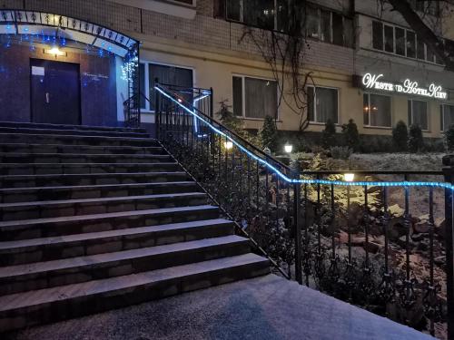Westend Hotel Kyiv في كييف: مجموعة من السلالم أمام مبنى ذو أضواء زرقاء