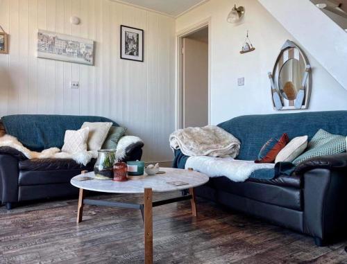 a living room with two blue couches and a table at Chalet 95, Kingsdown Park in Deal