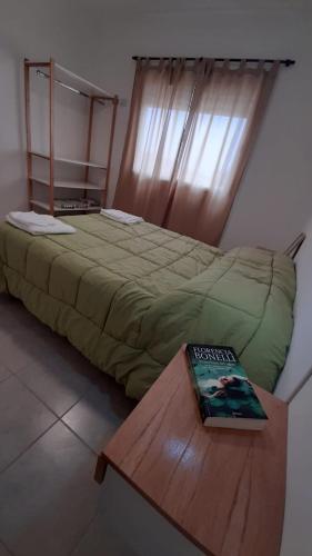 sypialnia z łóżkiem z książką na stole w obiekcie Departamentos A544 w mieście Santa Rosa