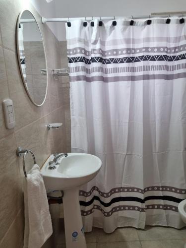 a bathroom with a sink and a shower curtain at Departamentos A544 in Santa Rosa