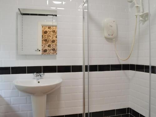 a bathroom with a sink and a shower at Kennels Cottage - Beaufort Estate in Belladrum