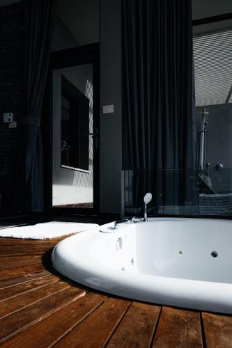 a bathroom with a white tub and a mirror at Diamond Mansion-Suite B in Had Nes
