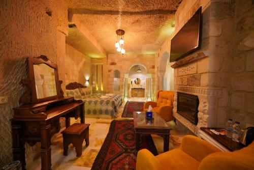 a living room with a fireplace and a piano at Shoestring Cave House in Goreme
