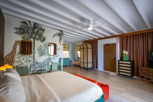 Cette chambre comprend un lit blanc et une fresque murale représentant des girafes. dans l'établissement The Pink Palm Hotel - Adults Only, à Charlotte-Amélie