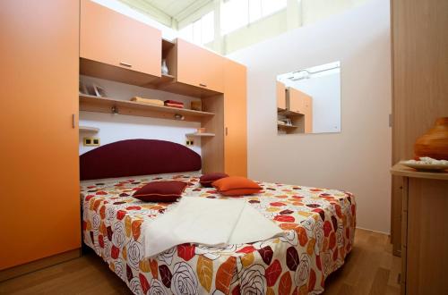 ein Schlafzimmer mit einem Bett in einem Zimmer in der Unterkunft Camping Village Le Esperidi in Marina di Bibbona