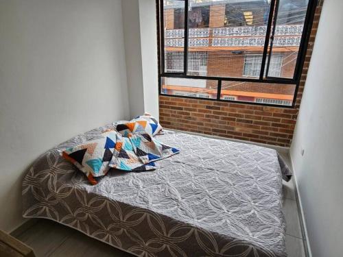 Cama en habitación con ventana en Increíble Apartamento Familiar, en Bogotá