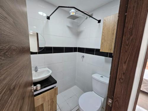 a bathroom with a toilet and a sink at Increíble Apartamento Familiar in Bogotá