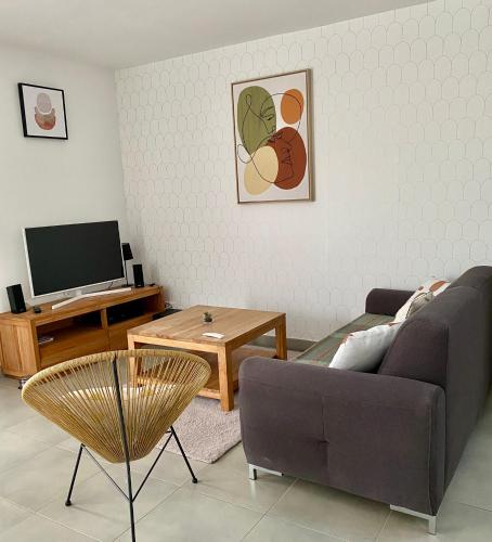 a living room with a couch and a tv at Villa Garance Ile et Villas Groix in Groix