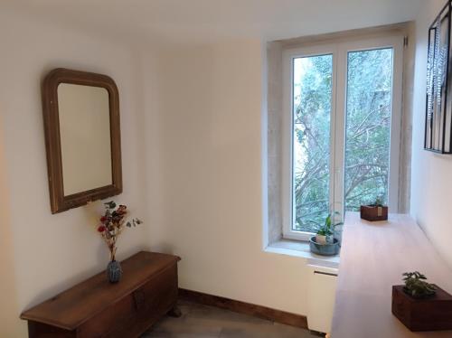 um quarto com um espelho e uma cómoda e uma janela em Logis proche des plages du débarquement em Vaucelles
