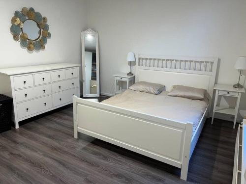 een witte slaapkamer met een wit bed en een spiegel bij Appartement City Enschede (free private parking) in Enschede