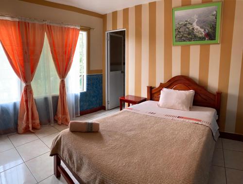 a bedroom with a bed and a window at Hotel Los Bancos in San Miguel de los Bancos