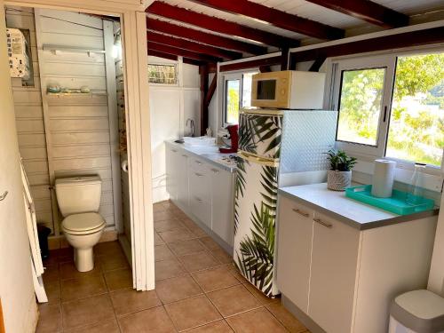 a small kitchen with a toilet and a refrigerator at LES GITES DE LA RESERVE in Bouillante