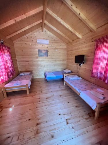 Cette chambre comprend 3 lits et une télévision. dans l'établissement Ethno village Moraca - Skadar lake, à Vranjina