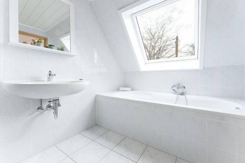 a white bathroom with a sink and a bath tub at Lehmberg Über den Feldern in Rathlau