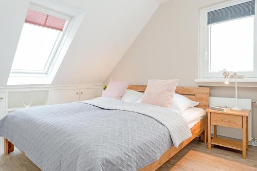 1 dormitorio blanco con 1 cama y 2 ventanas en Kammerweg 89 Grete, en Scharbeutz