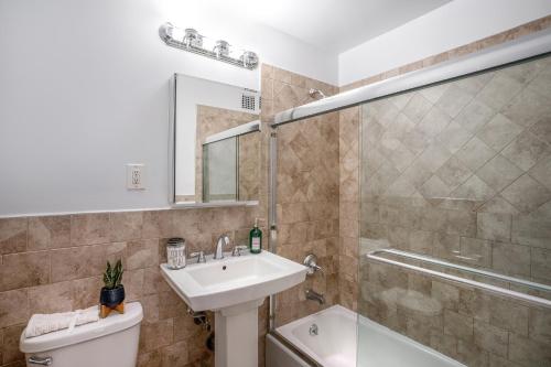 ein Bad mit einem Waschbecken, einem WC und einer Dusche in der Unterkunft LUXURY 4 BEDS 1.5 BATHS BY CENTRAL PARK in New York
