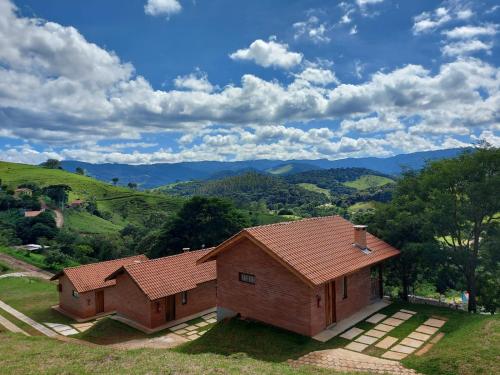 an aerial view of a house with mountains in the background at Chalés Santa Luzia in Santo Antônio do Pinhal