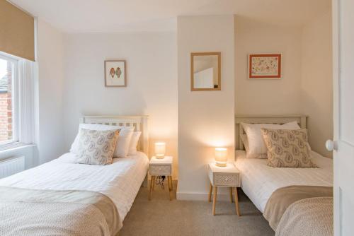 two beds in a room with two lamps on tables at Bunny Cottage by Bloom Stays in Hythe