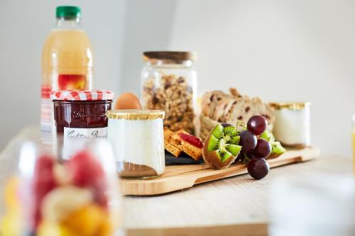 a table topped with a cutting board with different types of food at Appartement Ezean belfort ville in Belfort