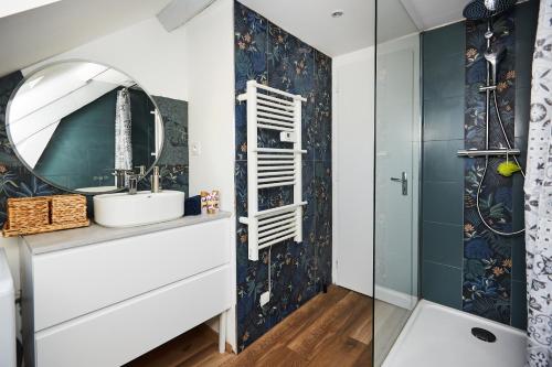 La salle de bains est pourvue d'un lavabo et d'un miroir. dans l'établissement Appartement Ezean belfort ville, à Belfort