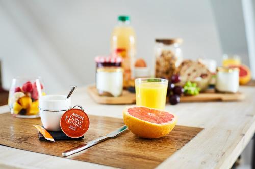 a cutting board with a piece of fruit and a glass of orange juice at Appartement Ezean belfort ville in Belfort