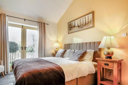 a bedroom with a large bed and a window at No 3 The Dairy in Llangefni