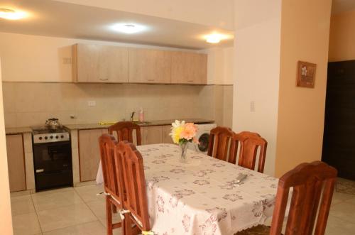 una cocina con una mesa con un jarrón de flores. en Apartamentos Naomi 1B en El Carmen