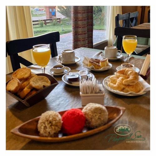 Una mesa cubierta con platos de comida y vasos de jugo de naranja. en Pampas al Sur, en Río Colorado