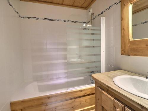 une salle de bain avec une baignoire et un lavabo dans l'établissement Charmant 3 Pièces, Pieds des Pistes, 7 Pers, Label Méribel, Wi-Fi, Balcon Orienté Sud-Est - FR-1-182-49, à Méribel